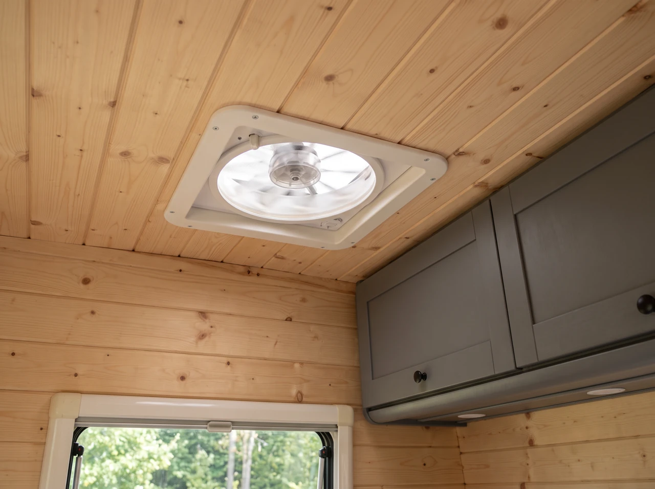 Dachlüfter in der Holzdecke des Campers mit dunkelgrauen Schränken – KI-Bild