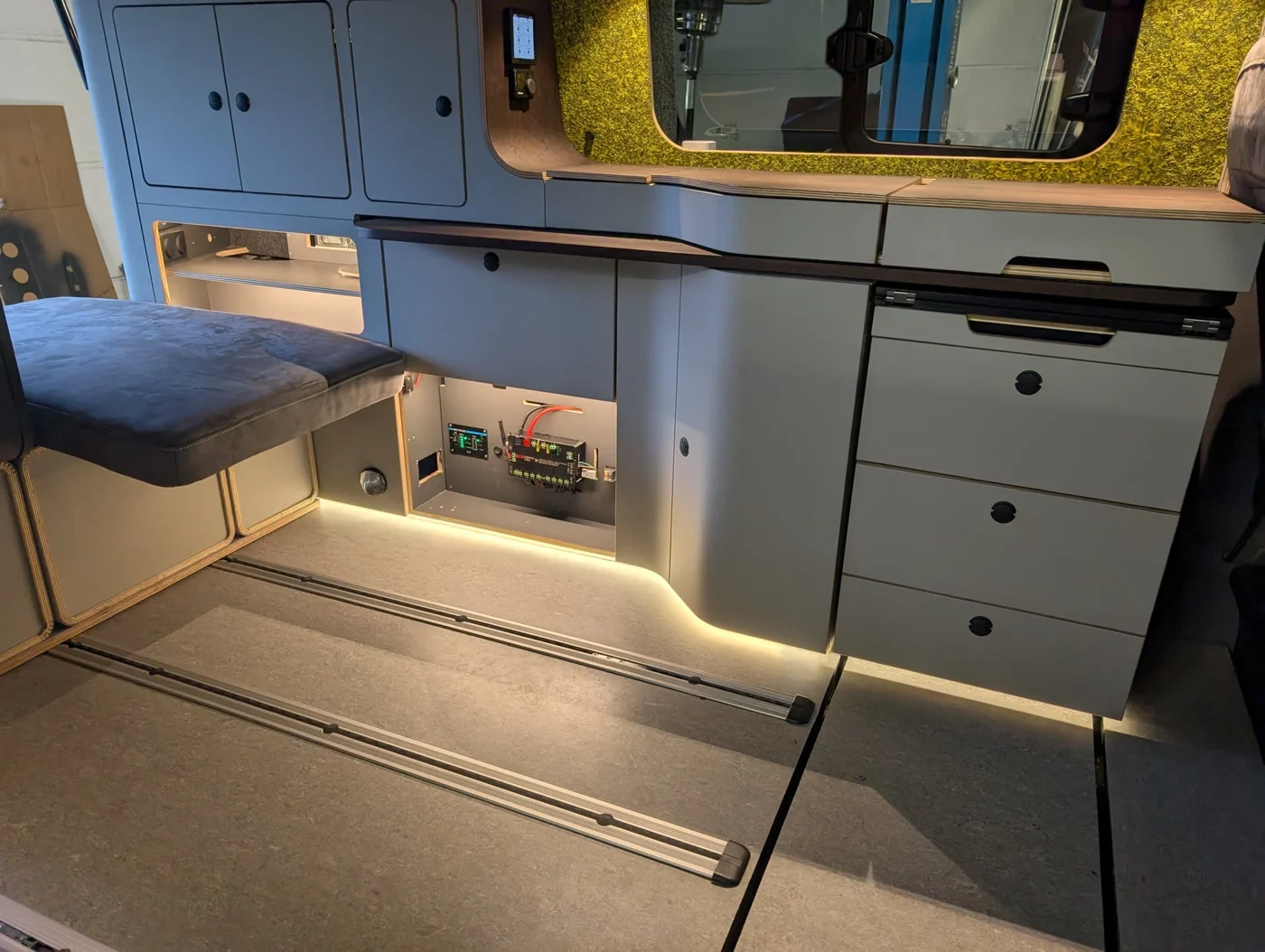 Echter Camper-Ausbau im Freescape: Möbel, Licht und ein geöffnetes Technikfach mit E1NS